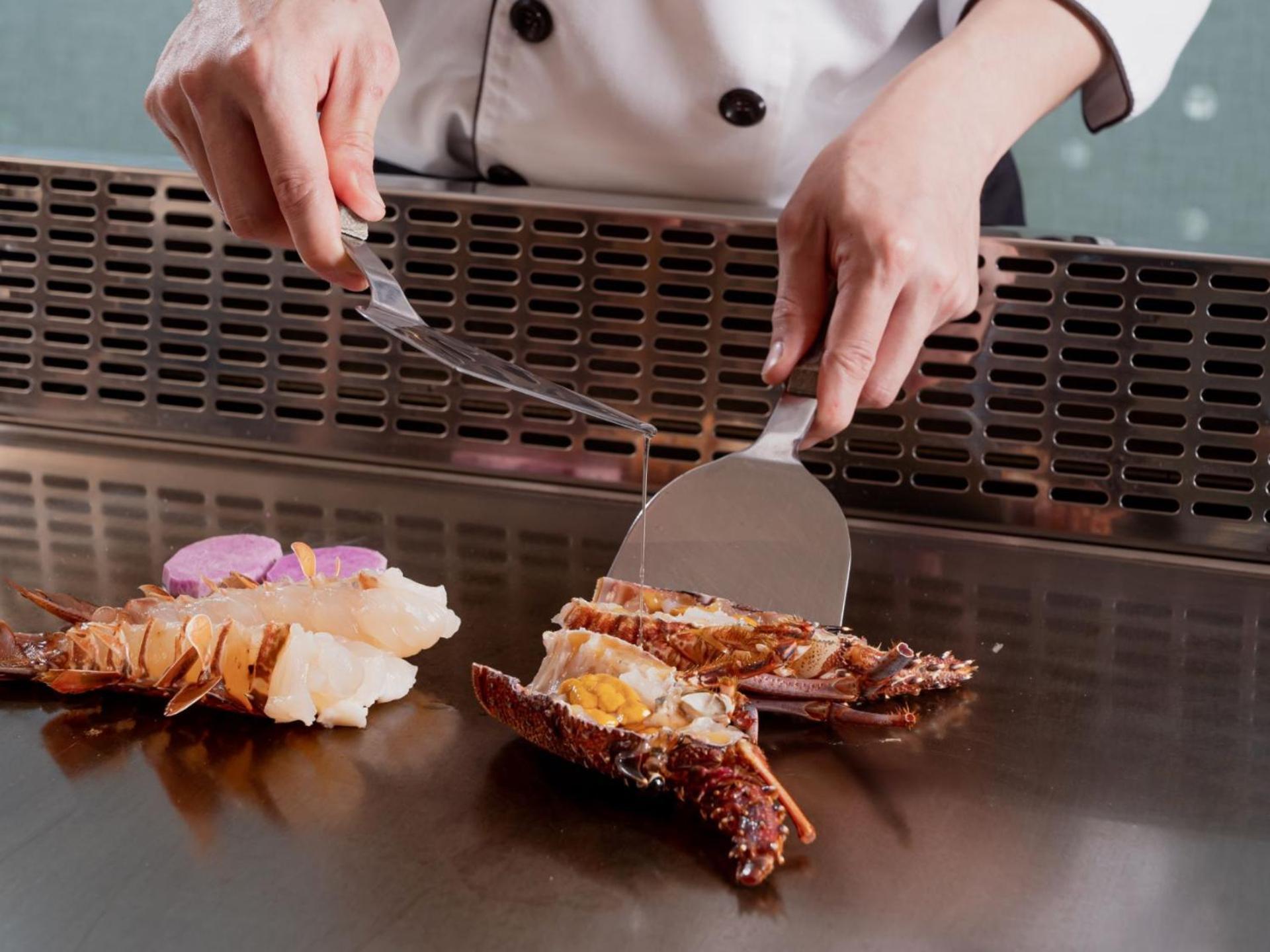 Windsor Hotel Taichung Exterior foto A chef using a fish knife to fillet a lobster